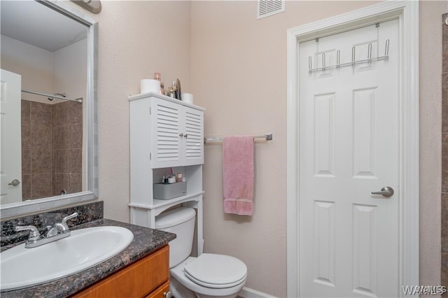 bathroom featuring vanity, toilet, and a shower