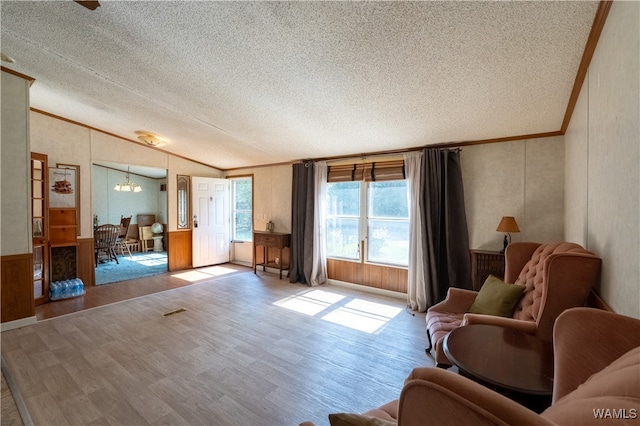 living room with a textured ceiling, light hardwood / wood-style flooring, lofted ceiling, and crown molding