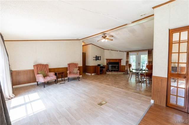 living area featuring a textured ceiling, ceiling fan, vaulted ceiling, and hardwood / wood-style flooring