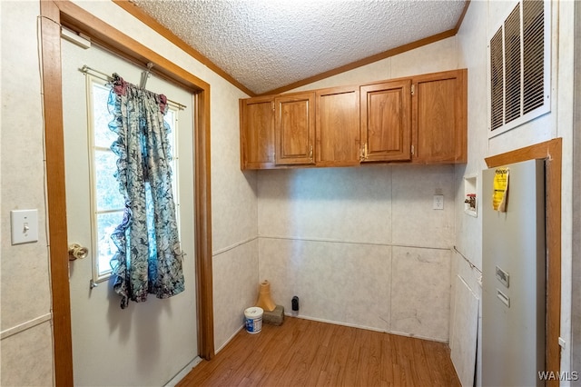 laundry area with cabinets, washer hookup, light hardwood / wood-style floors, a textured ceiling, and ornamental molding