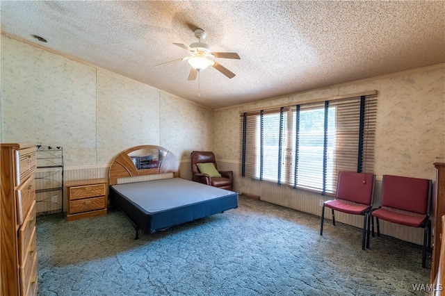 carpeted bedroom featuring ceiling fan and a textured ceiling