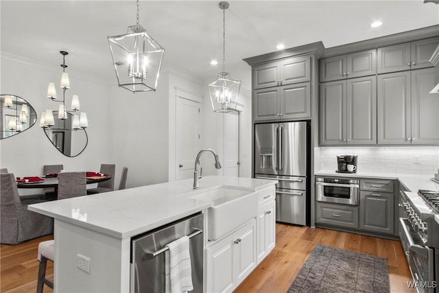301 Trails End Ln, Tuscaloosa, AL 35406 - kitchen featuring stainless steel appliances, gray cabinets, a sink, tasteful backsplash, and a notable chandelier