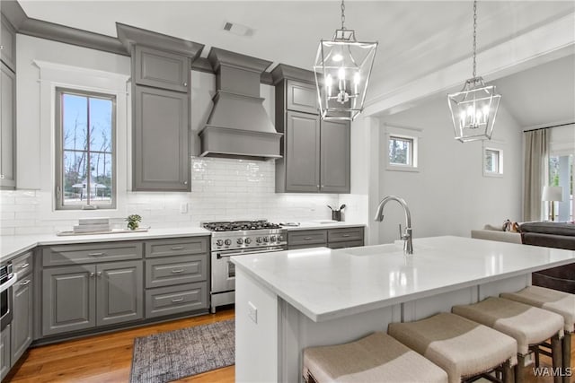 301 Trails End Ln, Tuscaloosa, AL 35406 - kitchen featuring a sink, light wood-style floors, custom range hood, gray cabinets, and stainless steel range
