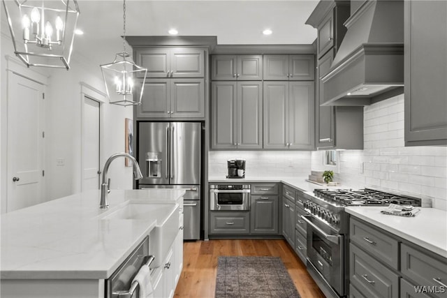 301 Trails End Ln, Tuscaloosa, AL 35406 - kitchen with premium range hood, gray cabinets, stainless steel appliances, and an inviting chandelier