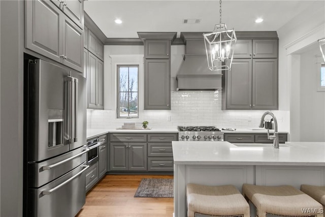 301 Trails End Ln, Tuscaloosa, AL 35406 - kitchen with high end fridge, a sink, a breakfast bar, gray cabinets, and premium range hood
