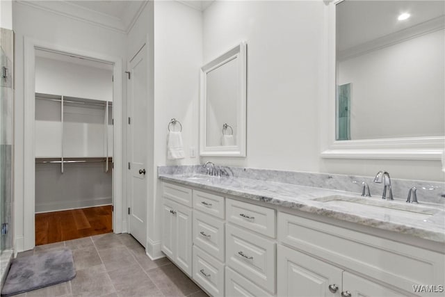 301 Trails End Ln, Tuscaloosa, AL 35406 - bathroom featuring a walk in closet, double vanity, crown molding, and a sink