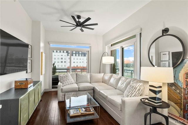 living room with ceiling fan, dark wood-type flooring, and a healthy amount of sunlight