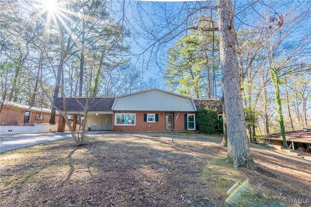 view of front of house featuring brick siding, concrete driveway, and a carport