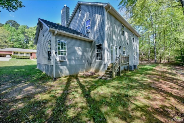 4401 Nicholas Ave, Northport, AL 35473 - back of house featuring a chimney, cooling unit, a lawn, and central AC