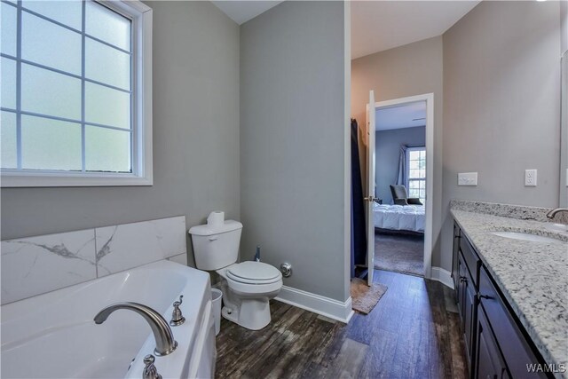 4401 Nicholas Ave, Northport, AL 35473 - ensuite bathroom with vanity, toilet, baseboards, a bath, and wood finished floors