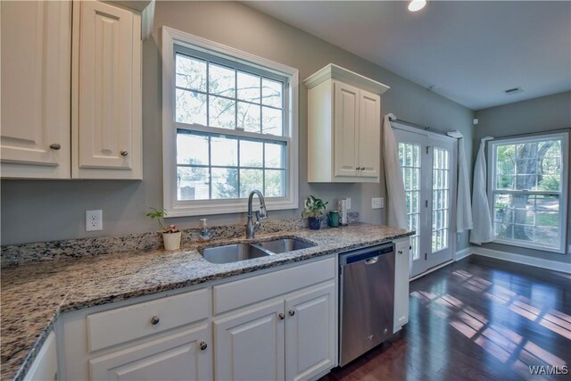 4401 Nicholas Ave, Northport, AL 35473 - kitchen featuring stainless steel dishwasher, a sink, dark wood-type flooring, white cabinetry, and light stone counters