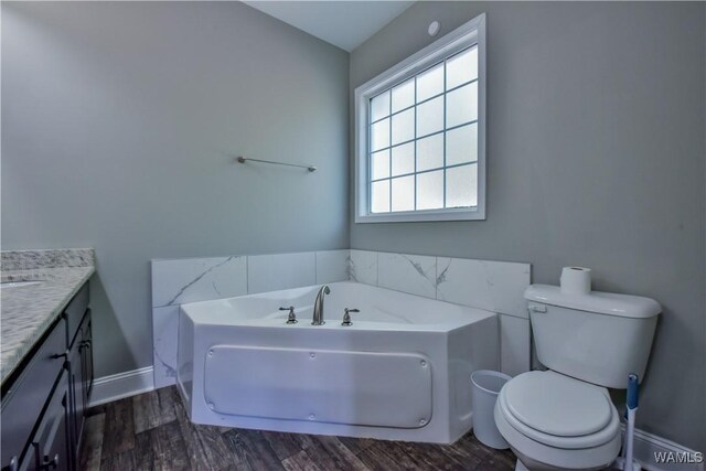 4401 Nicholas Ave, Northport, AL 35473 - bathroom with vanity, a garden tub, wood finished floors, and toilet