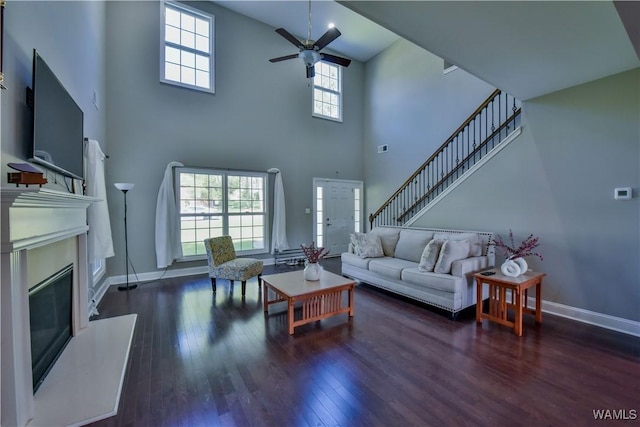 4401 Nicholas Ave, Northport, AL 35473 - living room with a ceiling fan, hardwood / wood-style floors, a towering ceiling, a glass covered fireplace, and baseboards