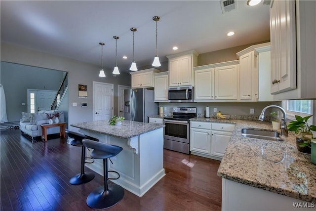 4401 Nicholas Ave, Northport, AL 35473 - kitchen with appliances with stainless steel finishes, a sink, a kitchen island, a breakfast bar area, and light stone countertops
