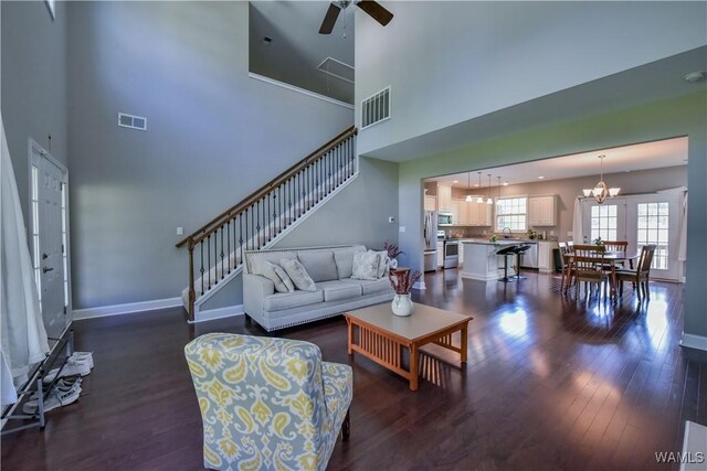 4401 Nicholas Ave, Northport, AL 35473 - living area featuring a ceiling fan, a chandelier, dark wood-style floors, a high ceiling, and stairway