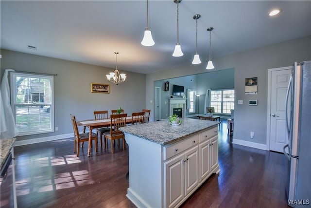 4401 Nicholas Ave, Northport, AL 35473 - kitchen with freestanding refrigerator, healthy amount of natural light, dark wood-style floors, and a chandelier