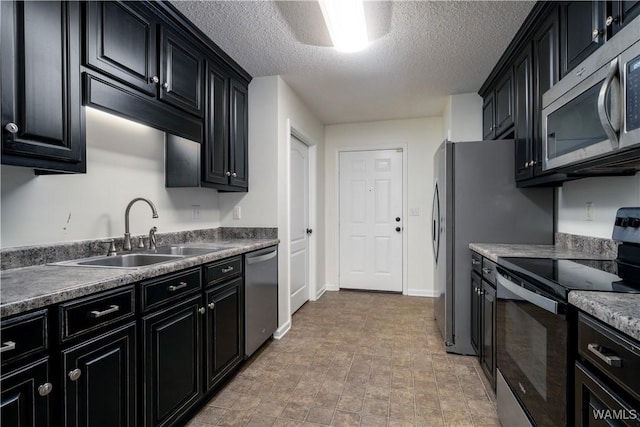 kitchen featuring a textured ceiling, sink, and appliances with stainless steel finishes