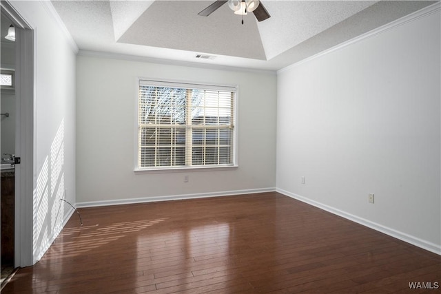 empty room featuring ceiling fan, dark hardwood / wood-style floors, a raised ceiling, and a textured ceiling