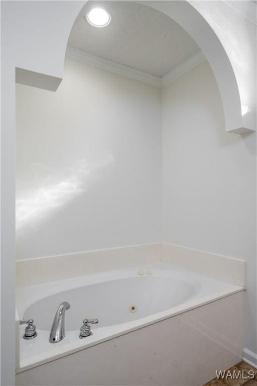 bathroom featuring ornamental molding and a bath