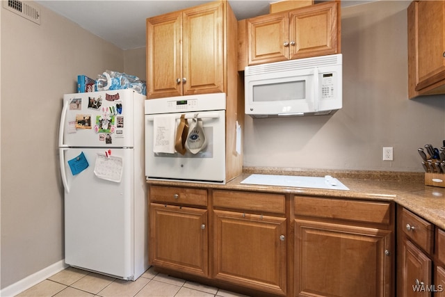 kitchen with white appliances and light tile patterned floors