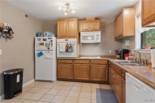 kitchen with a chandelier, light tile patterned floors, white appliances, and sink