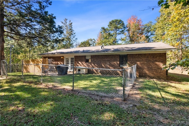 back of property featuring french doors and a lawn