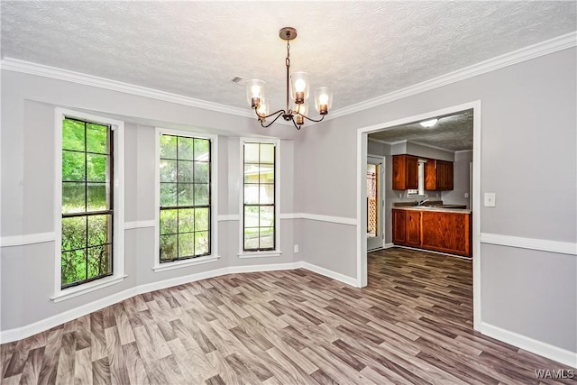 1924 Still Oaks Dr, Montgomery, AL 36117 - unfurnished dining area with a chandelier, wood finished floors, a textured ceiling, and crown molding