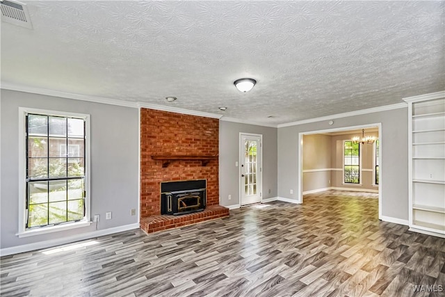 1924 Still Oaks Dr, Montgomery, AL 36117 - unfurnished living room featuring wood finished floors, a chandelier, a textured ceiling, crown molding, and a fireplace