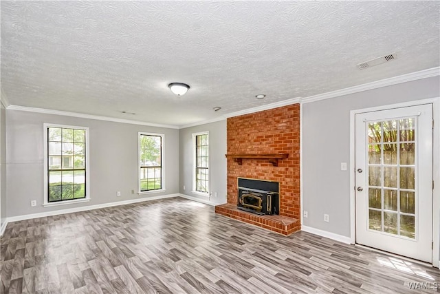 1924 Still Oaks Dr, Montgomery, AL 36117 - unfurnished living room with wood finished floors, a textured ceiling, ornamental molding, and a brick fireplace
