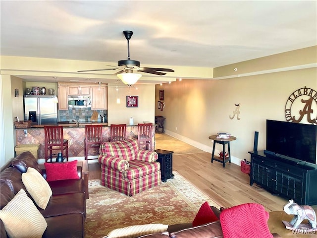 living room featuring ceiling fan and light hardwood / wood-style flooring