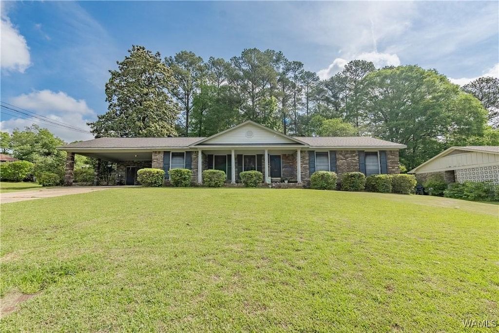 single story home with brick siding, an attached carport, driveway, and a front yard
