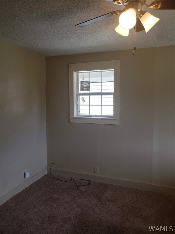 carpeted empty room with ceiling fan and a textured ceiling