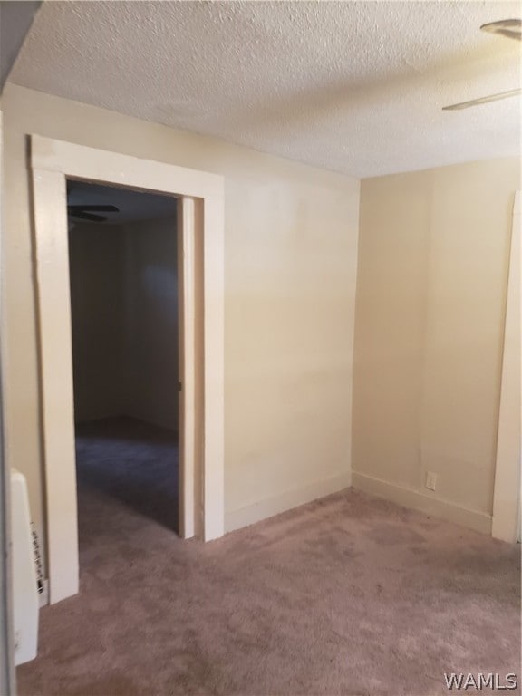 carpeted empty room featuring a textured ceiling