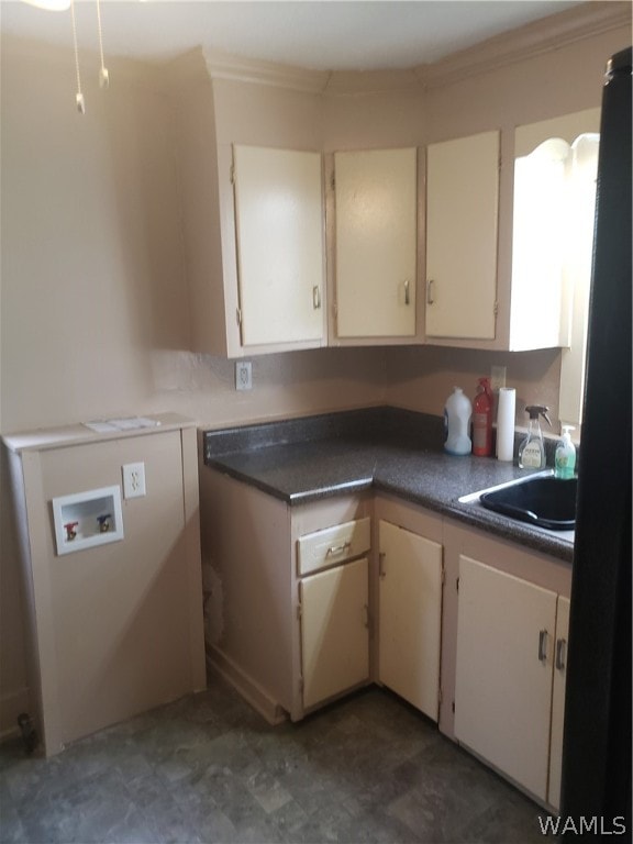 kitchen featuring cream cabinets, crown molding, and sink