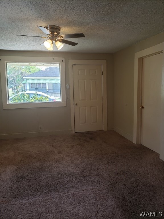 carpeted spare room with ceiling fan and a textured ceiling