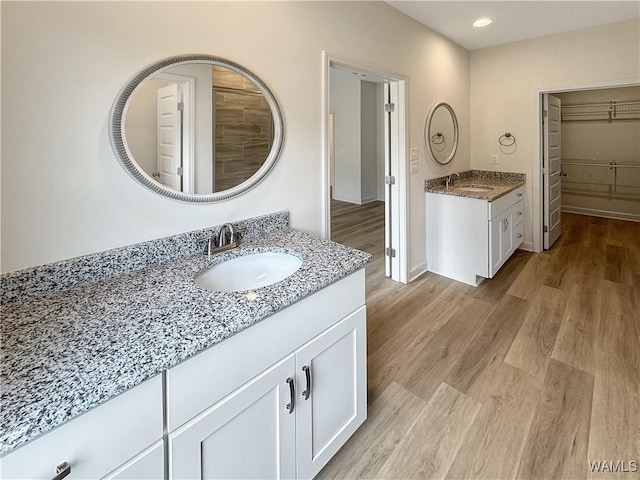 13879 Gilliam Rd, Berry, AL 35546 - full bathroom with two vanities, wood finished floors, recessed lighting, and a spacious closet