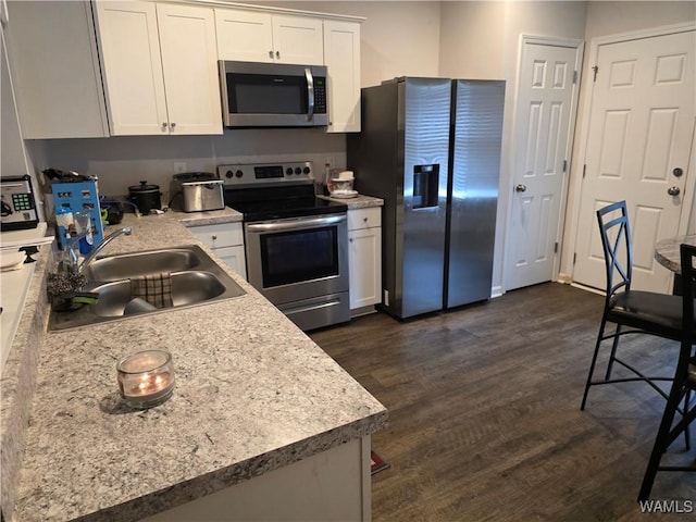 12376 Choctaw Cir, Moundville, AL 35474 - kitchen featuring appliances with stainless steel finishes, white cabinets, dark wood finished floors, light countertops, and a sink