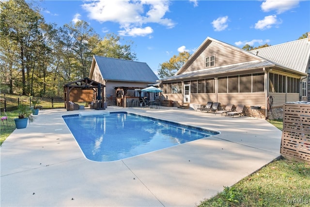 view of swimming pool featuring a gazebo, a sunroom, and a patio area