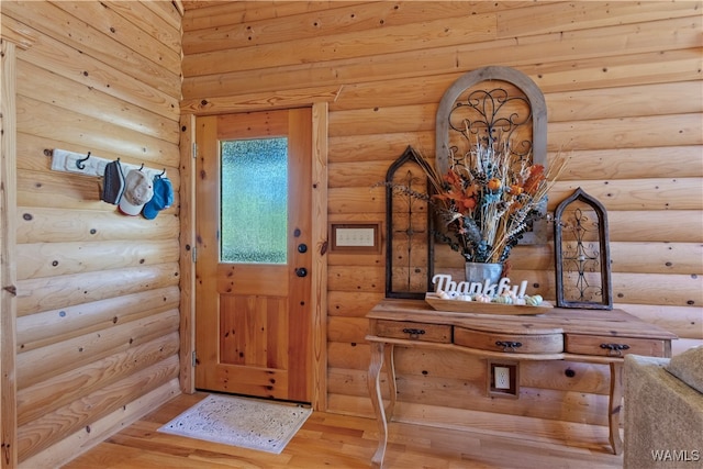 interior space with light hardwood / wood-style floors and rustic walls