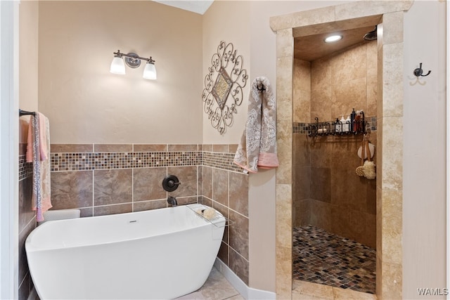 bathroom featuring tile patterned floors, shower with separate bathtub, and tile walls