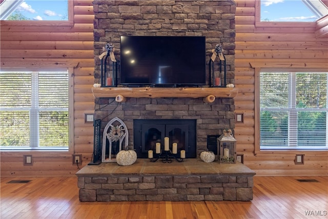 interior details featuring a fireplace, log walls, and hardwood / wood-style flooring