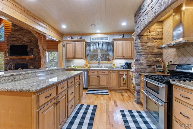 kitchen with sink, wall chimney exhaust hood, stainless steel appliances, light hardwood / wood-style flooring, and wood ceiling