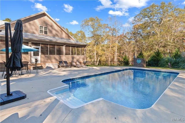 view of swimming pool with a patio and a sunroom