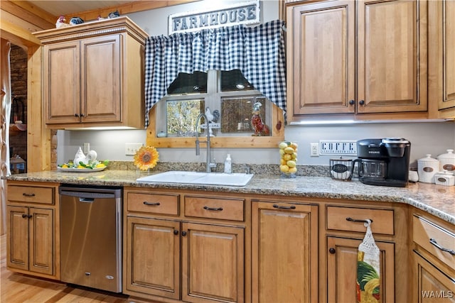 kitchen with light wood-type flooring, light stone counters, stainless steel dishwasher, and sink