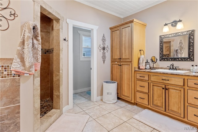 bathroom featuring tile patterned floors, vanity, and a tile shower