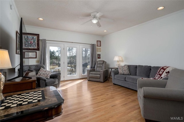 living area with crown molding, recessed lighting, light wood-type flooring, and a textured ceiling