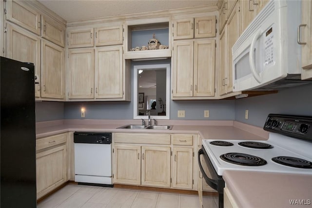 kitchen with white appliances, light brown cabinets, light countertops, and a sink