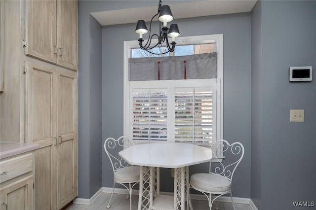 dining space with baseboards and an inviting chandelier