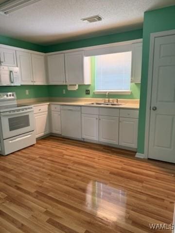 kitchen with white cabinetry, light hardwood / wood-style flooring, white appliances, and sink