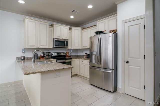 kitchen with appliances with stainless steel finishes, sink, light stone counters, kitchen peninsula, and crown molding